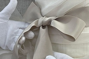 A detail of a bow from a Vera Wang wedding gown displayed in a custom vitrine