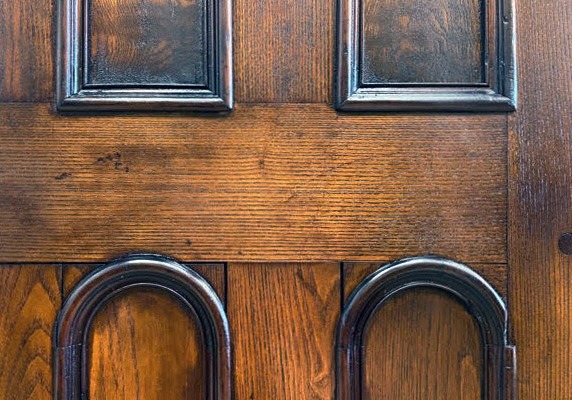 A detail of the arched inset panels on the door of a 19th century wood wardrobe after refinishing and restoration.