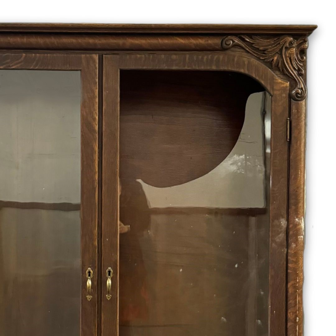 Detial of the broken glass panel in an antique china cabinet with carved design