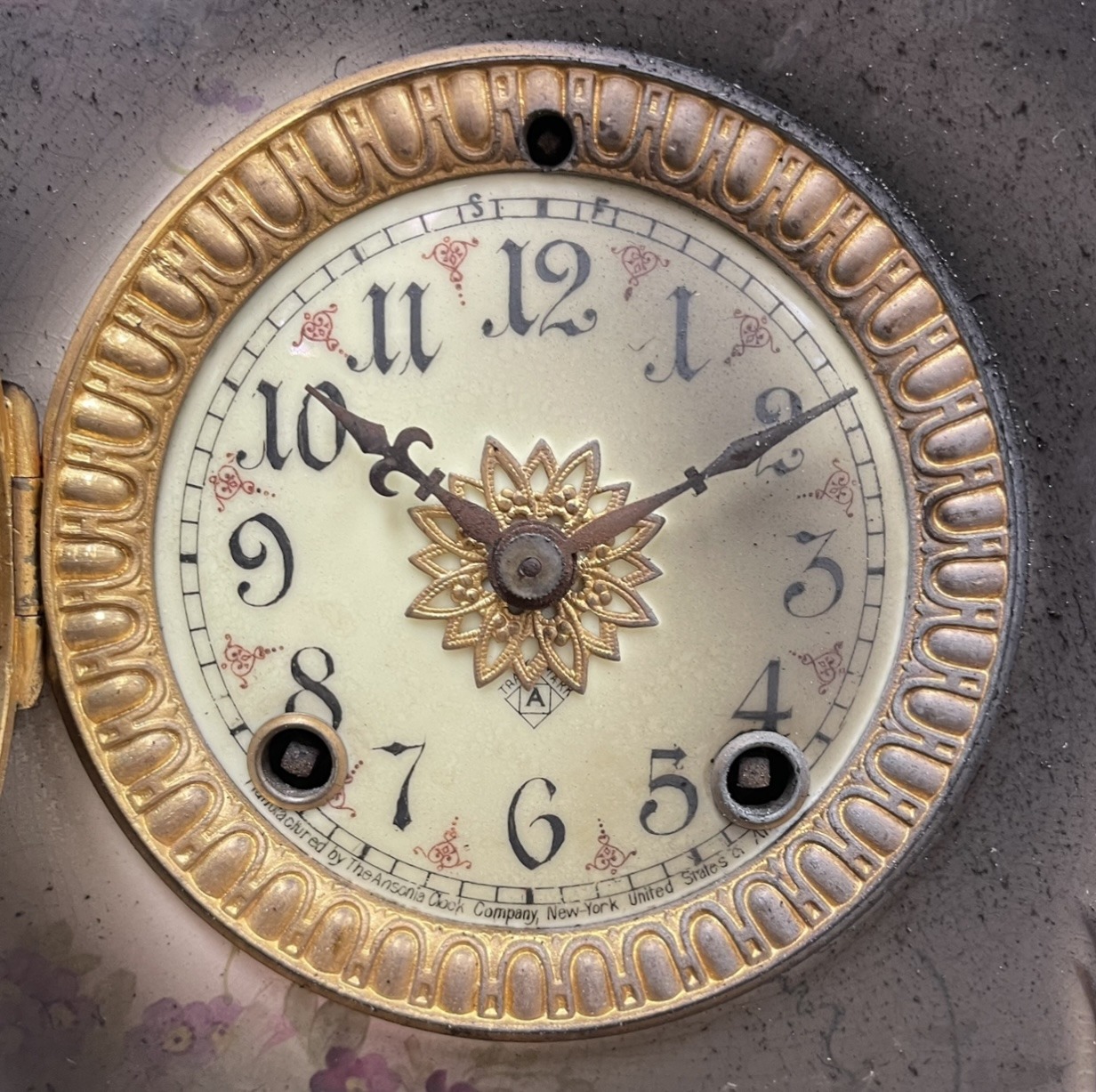 A fire damaged antique clock face before restoration