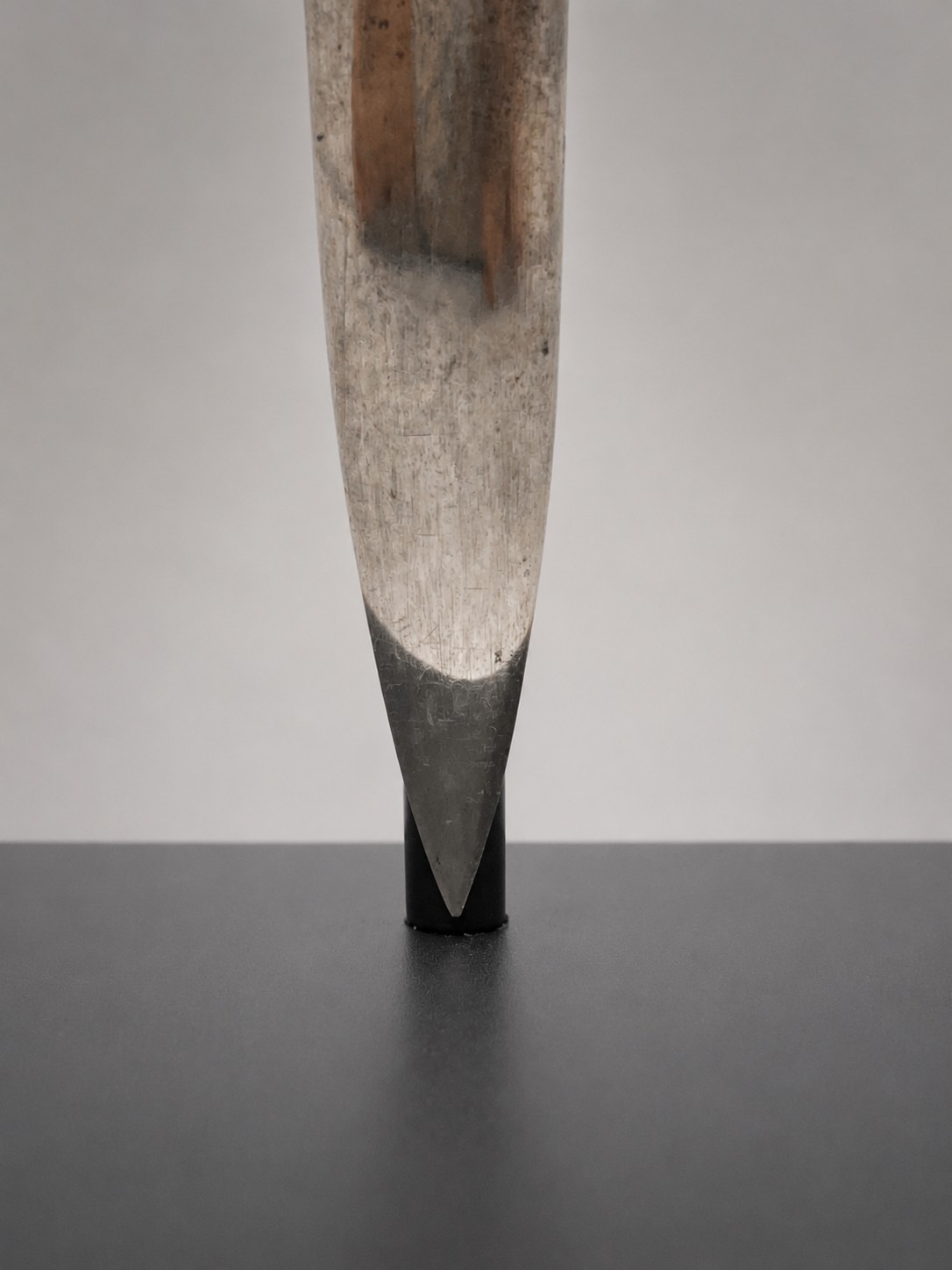 Close-up of the sword's blade tip resting on the custom mount's concealed magnetic base.