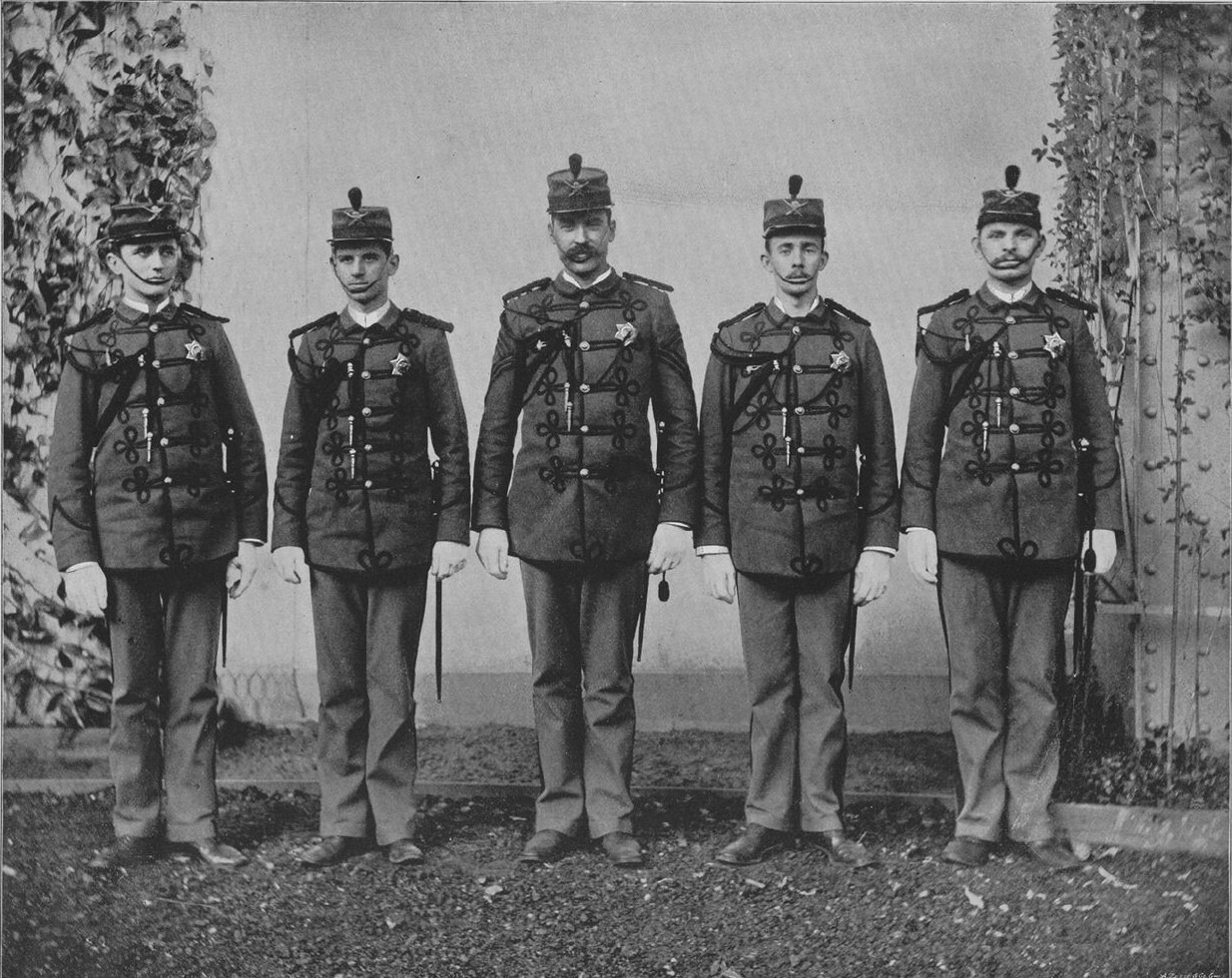 Black-and-white 1893 photograph of five Columbian Exposition guards in uniform, each holding a sword at his side.