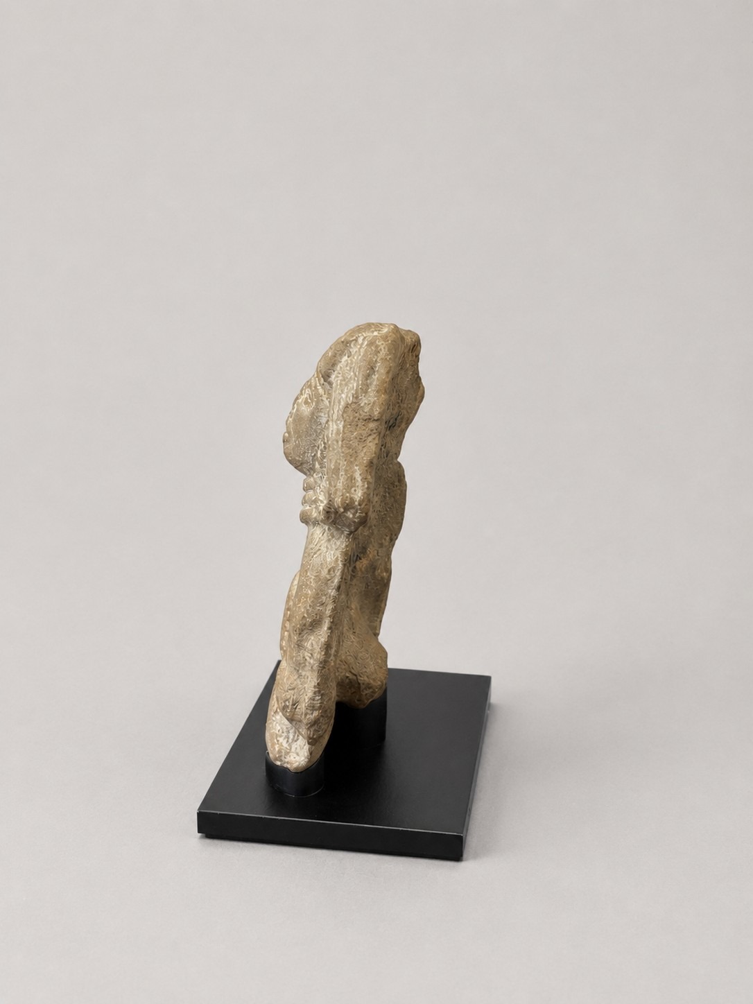Pre-Columbian stone sculpture on a custom mount, viewed from the side