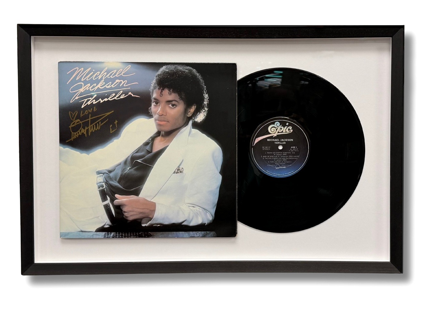 Framed autographed Michael Jackson Thriller album cover displayed beside its vinyl record